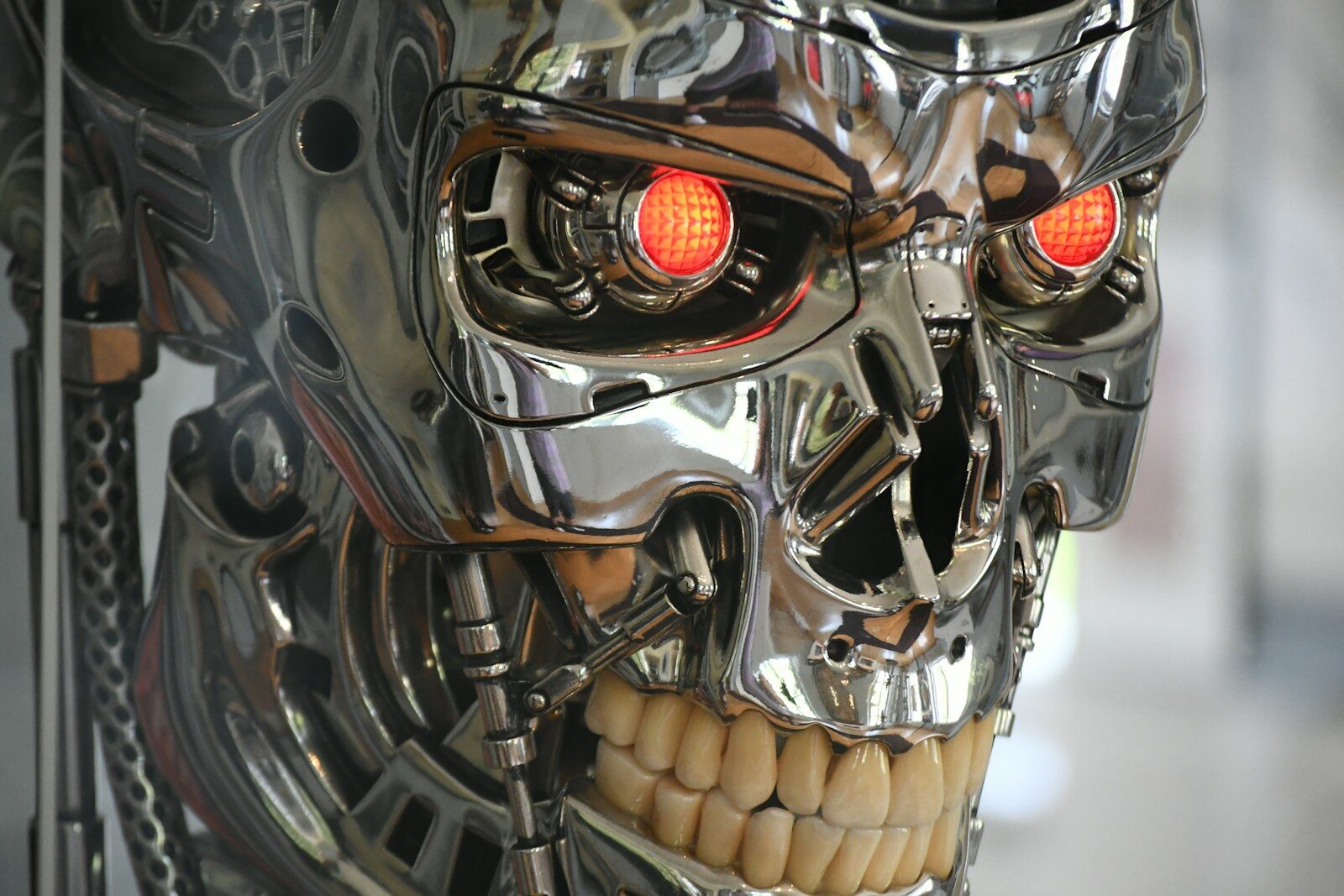 The Global Debate Over New AI Weapons Is Intensifying Chrome robotic skull with glowing red eyes.