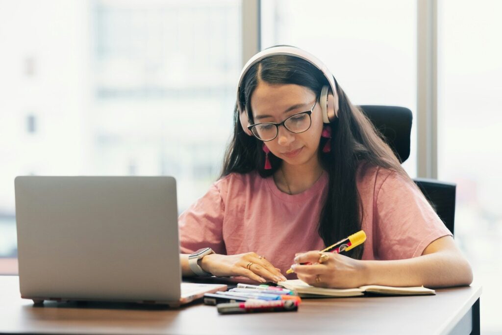 Why Wealthy Families Rethinking Traditional Schools in New Age AI Young woman wearing headphones studying at desk