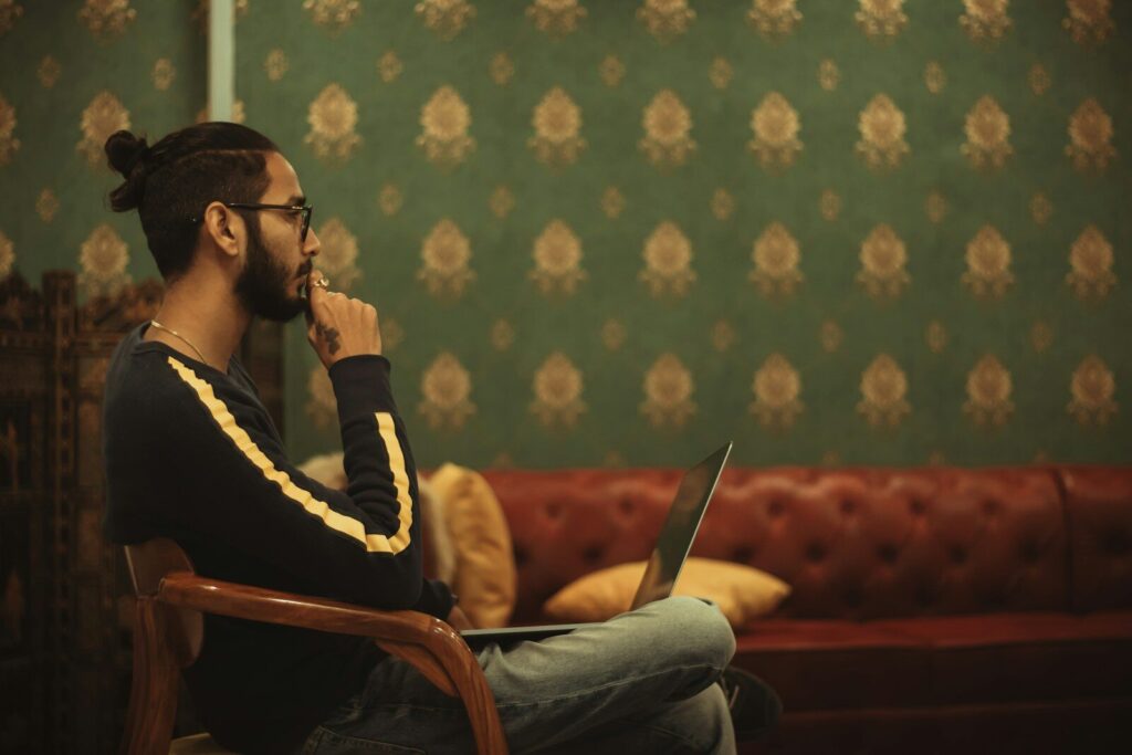 Is ChatGPT Changing the Way You Think? How to Use AI Without Losing Your Critical Thinking Skills man sitting on chair while using laptop on his lap near sofa inside room