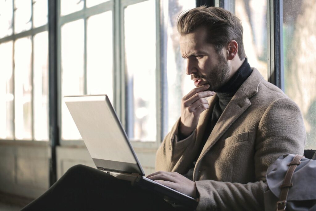 Is ChatGPT Changing the Way You Think? How to Use AI Without Losing Your Critical Thinking Skills man holding his chin facing laptop computer
